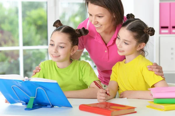 Flickor och mamma gör läxor — Stockfoto