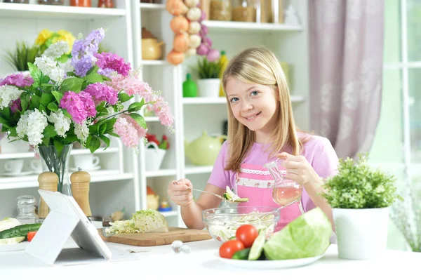 Süßes Kleines Mädchen Gießt Frischen Salat Auf Küchentisch — Stockfoto