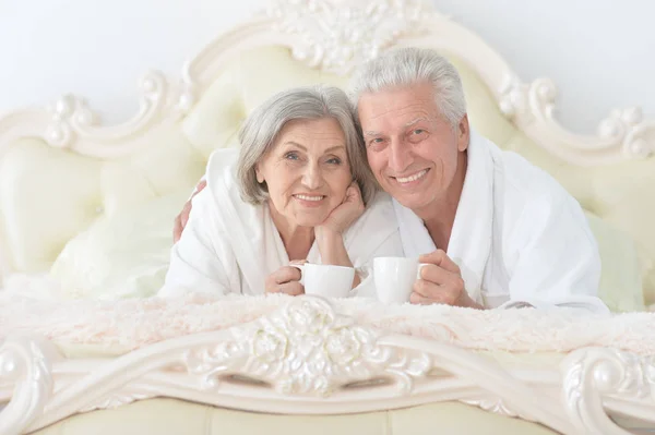 Senior echtpaar in bed met thee — Stockfoto