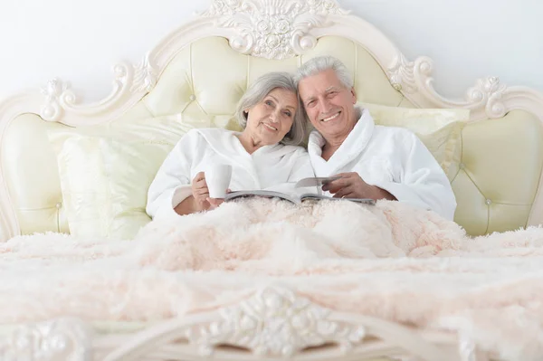 Старшая пара в постели с чаем — стоковое фото