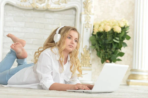 Ragazza Adolescente Bionda Riccia Cuffie Sdraiato Sul Pavimento Utilizzando Computer — Foto Stock