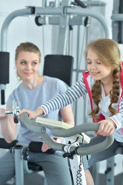 运动的年轻女子训练与十几岁的女儿在健身房 — 图库照片