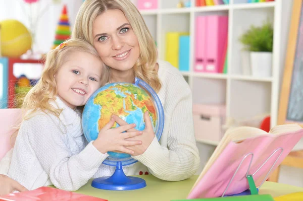Thoughtful Mother Daughter Sitting Table Globe — Stock Photo, Image