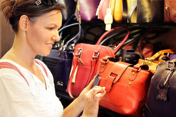 Junge Frau wählt Handtasche — Stockfoto