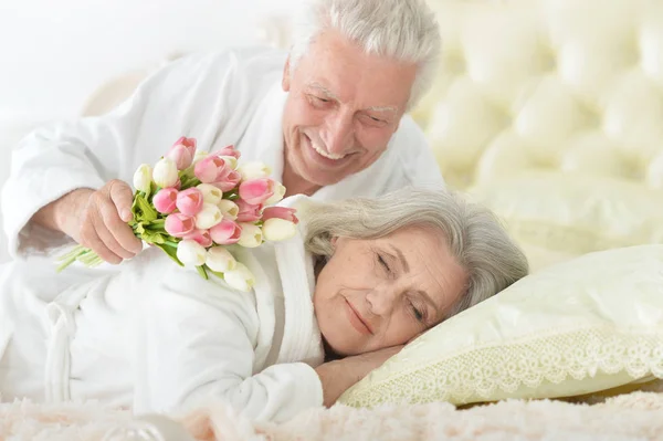 Seniorchef schenkt einer Frau Blumen — Stockfoto