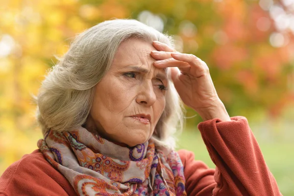 Portret Senior Kobieta Zatroskana Bólem Głowy Parku — Zdjęcie stockowe