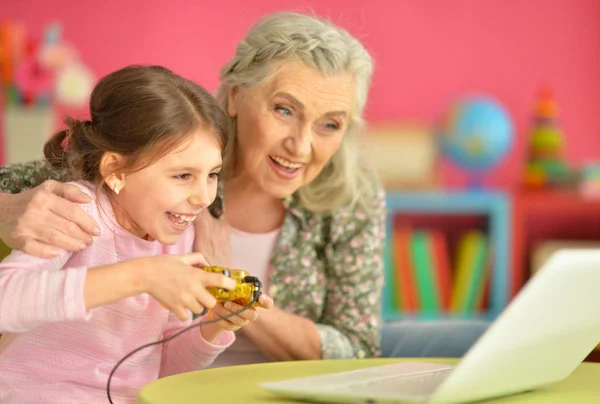 Flicka med mormor använder laptop — Stockfoto