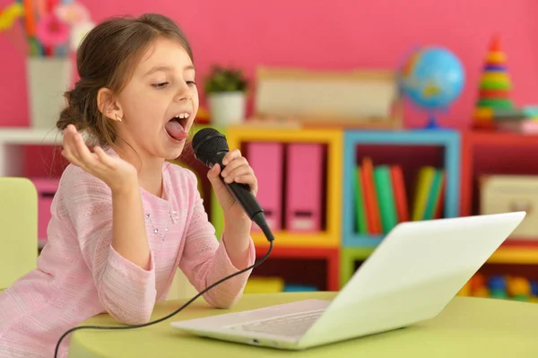 Αξιολάτρευτο Κοριτσάκι Χρησιμοποιώντας Σύγχρονο Φορητό Υπολογιστή Και Τραγουδώντας Καραόκε — Φωτογραφία Αρχείου