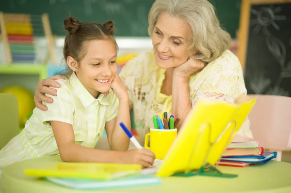 Mormor Med Söt Liten Flicka Göra Läxor Tillsammans — Stockfoto