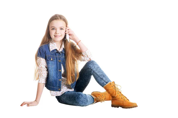 快乐的小女孩在牛仔裤谈论在电话隔绝在白色背景上 — 图库照片