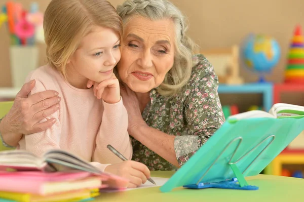 Бабуся і онука роблять домашнє завдання — стокове фото