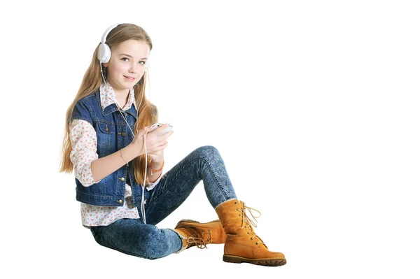 ジーンズは 白い背景で隔離のスマート フォンで音楽を聴いて幸せな少女 — ストック写真