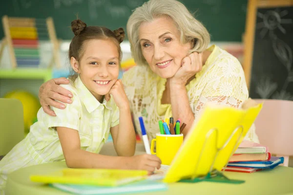 Mormor Med Söt Liten Flicka Göra Läxor Tillsammans — Stockfoto