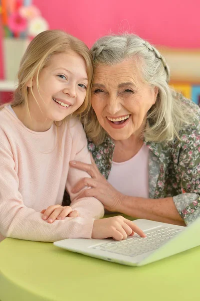 Menina com avó usando laptop — Fotografia de Stock
