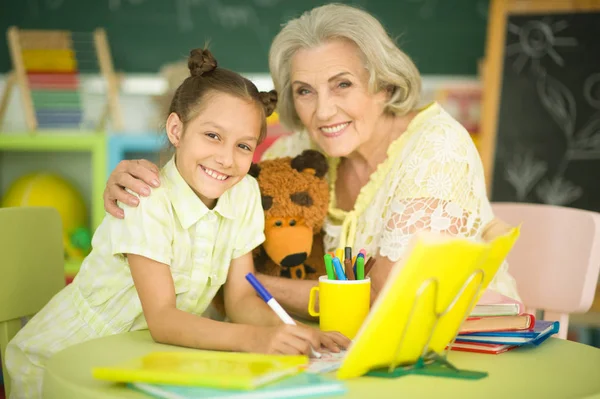 Mormor Med Söt Liten Flicka Göra Läxor Tillsammans — Stockfoto