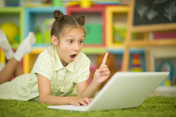 Ładna Dziewczyna Pomocą Laptopa Skierowaną Górę Palcem Leżąc Podłodze Domu — Zdjęcie stockowe