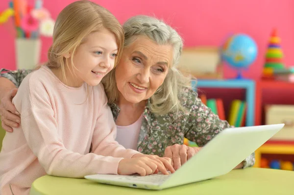 Mädchen mit Großmutter mit Laptop — Stockfoto