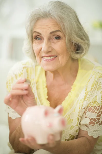 Old woman with piggy bank — Stock Photo, Image