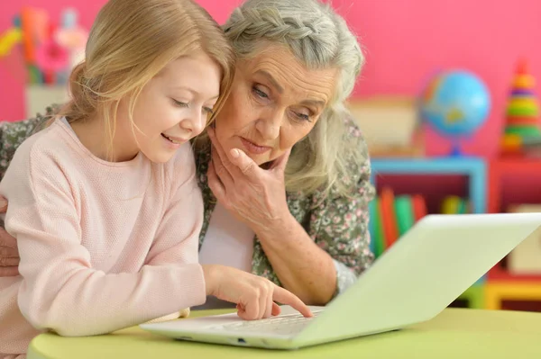 Chica con la abuela usando el ordenador portátil — Foto de Stock