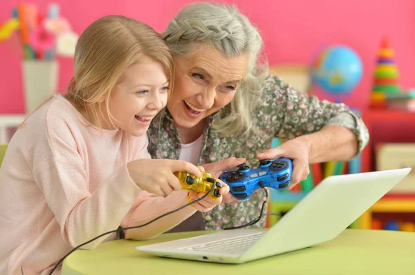 Meisje met grootmoeder met behulp van laptop — Stockfoto