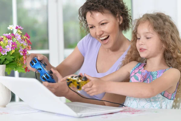 Mãe e filha jogando jogo no laptop — Fotografia de Stock