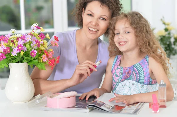 Madre con hija pequeña con revista — Foto de Stock