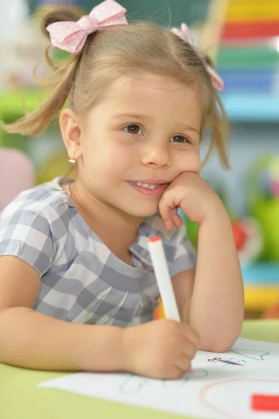 描くかわいい女の子は 彼女の部屋のテーブルに座ってペンを感じた — ストック写真