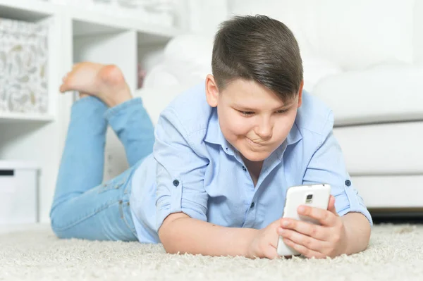小男孩与智能手机玩游戏在家里 — 图库照片