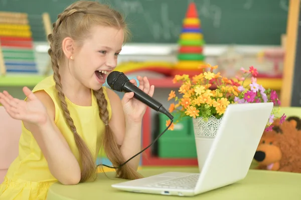 Menina Bonito Cantando Karaoke Com Laptop Enquanto Sentado Mesa — Fotografia de Stock
