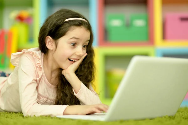 Menina Bonito Emocional Usando Laptop Enquanto Deitado Chão Verde Casa — Fotografia de Stock