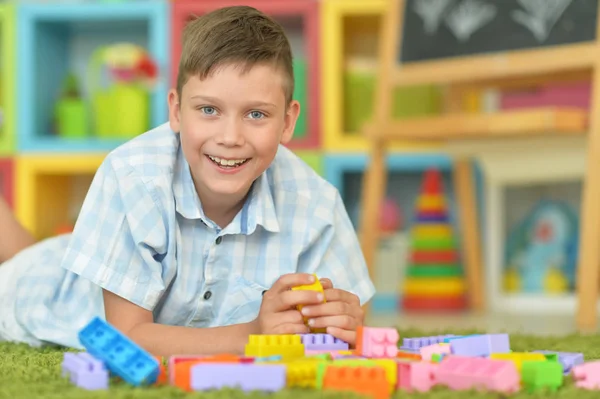 Lächelnder Junge Spielt Mit Bunten Plastikklötzen Auf Dem Boden — Stockfoto