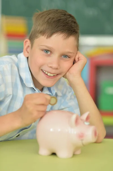 Young Boy Putting Coin Piggy Bank — Stock Photo, Image