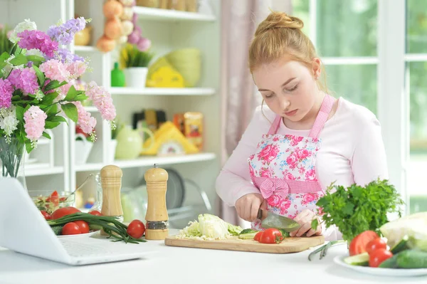 台所のテーブルに新鮮なサラダを準備するかわいい十代の少女 — ストック写真