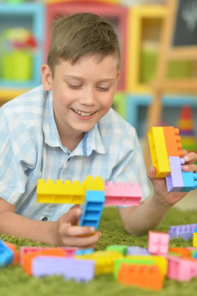 Lächelnder Junge Spielt Mit Bunten Plastikklötzen Auf Dem Boden — Stockfoto