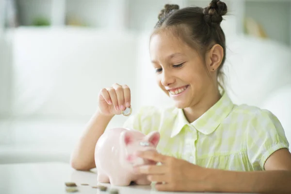 Schattig Klein Meisje Met Een Spaarvarken Bank Thuis — Stockfoto