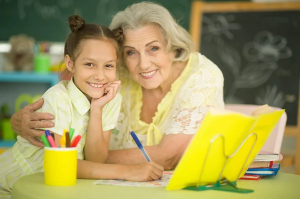 Mormor Med Söt Liten Flicka Göra Läxor Tillsammans — Stockfoto