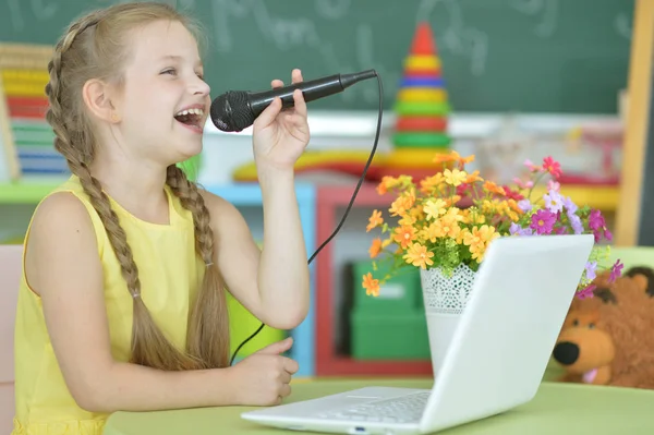 Schattig Meisje Zingen Karaoke Met Laptop Zittend Aan Tafel — Stockfoto