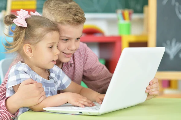 Brother and sister using laptop — Stock Photo, Image