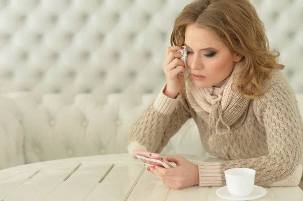 young beautiful crying  woman using smartphone