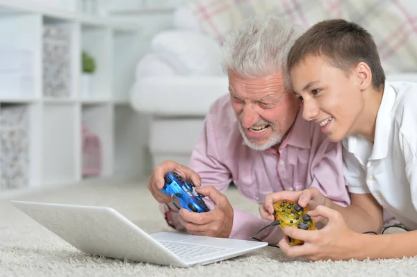 Großvater Und Enkel Liegen Auf Dem Boden Und Spielen Computerspiele — Stockfoto