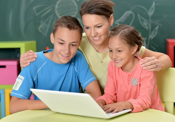 Mãe e crianças com laptop — Fotografia de Stock