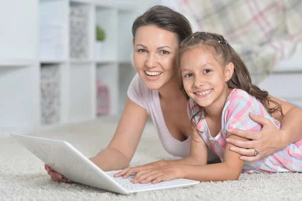 Feliz Madre Hija Usando Ordenador Portátil Juntos Mientras Están Tumbados —  Fotos de Stock