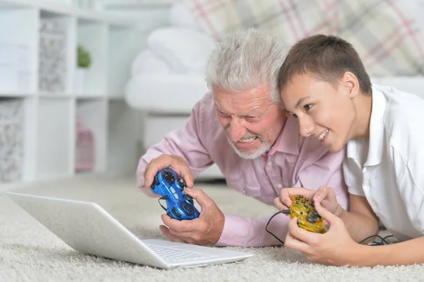 Großvater Und Enkel Liegen Auf Dem Boden Und Spielen Computerspiele — Stockfoto