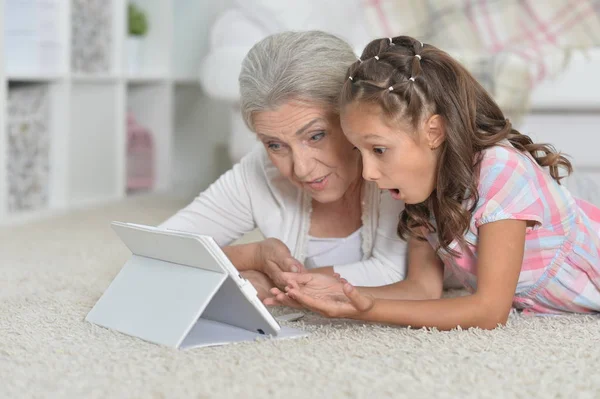 Dziewczyna z babcia za pomocą tabletu — Zdjęcie stockowe