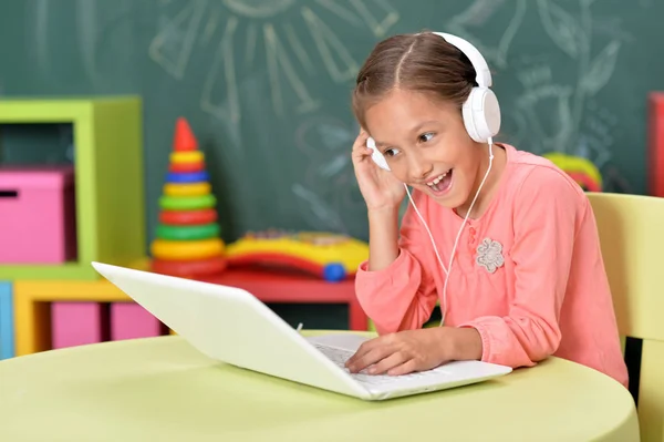 教室でノート パソコンを使用してヘッドフォンでかわいい女の子 — ストック写真