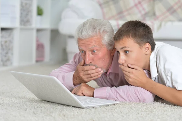 Avô Com Neto Usando Laptop Enquanto Deitado Chão Casa — Fotografia de Stock