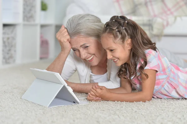 Flicka med mormor på surfplatta — Stockfoto