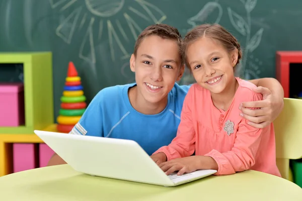 Hermano y hermana usando laptop —  Fotos de Stock