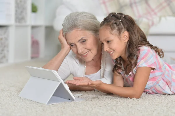 Flicka med mormor på surfplatta — Stockfoto