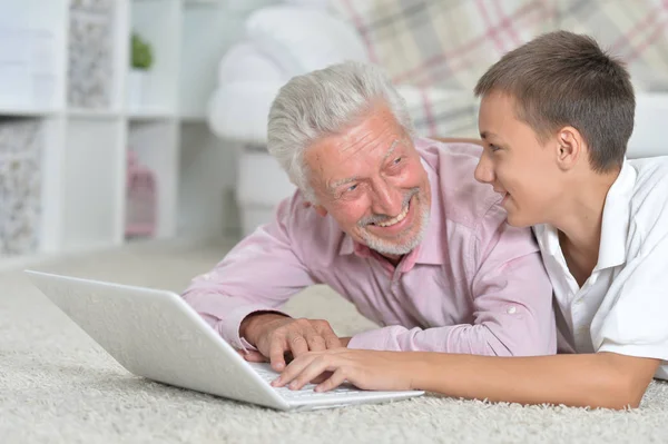 Avô Com Neto Usando Laptop Enquanto Deitado Chão Casa — Fotografia de Stock